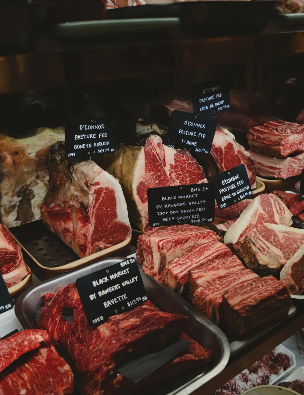 Balcão de açougue com cortes de carne identificados